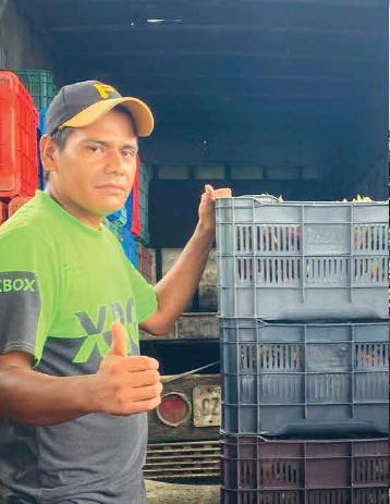 José Isaias Jorge Carballo beside produce crates
